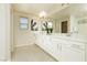 Bright bathroom with double vanity, white cabinets, and decorative plants at 6730 Pivot Point St, Las Vegas, NV 89148