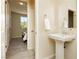 A powder room with a pedestal sink, neutral paint, and wood-look tile flooring at 6730 Pivot Point St, Las Vegas, NV 89148