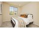 Cozy bedroom with neutral walls, wood-look tile flooring, and a large window at 6730 Pivot Point St, Las Vegas, NV 89148