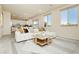 Open-concept living room with abundant natural light, a white sofa, and a view into the kitchen at 6730 Pivot Point St, Las Vegas, NV 89148