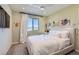 Bedroom with light green walls, grey carpet, white curtains and modern light fixture at 6938 Feather Hill St, North Las Vegas, NV 89086