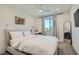 Bright bedroom featuring a large bed, stylish decor, and a window offering natural light and a view at 6938 Feather Hill St, North Las Vegas, NV 89086