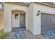 Stylish front entrance showcasing a paved walkway, stucco walls, and a cozy covered entryway with a gray-blue front door at 6938 Feather Hill St, North Las Vegas, NV 89086
