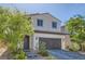 Inviting home exterior with a two-car garage, well-manicured landscaping, and a welcoming entrance at 6938 Feather Hill St, North Las Vegas, NV 89086