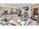 Open-concept living space featuring a large sectional sofa, marble coffee table, and seamless flow into the kitchen and dining areas at 6938 Feather Hill St, North Las Vegas, NV 89086