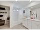 Bright bathroom with double vanity, bathtub and shower combination, and organized closet shelving at 7011 Toll Mountain St, North Las Vegas, NV 89086
