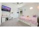 Bright bedroom with a TV, desk, and white bed with storage drawers at 7011 Toll Mountain St, North Las Vegas, NV 89086