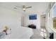 A bright bedroom features a plush bed, wall-mounted TV, and windows providing natural light and scenic views at 7011 Toll Mountain St, North Las Vegas, NV 89086