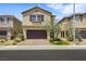 Two story home featuring desert landscaping, a brick driveway, and a two-car garage at 7011 Toll Mountain St, North Las Vegas, NV 89086