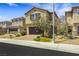 Two-story home showcases manicured desert landscaping, brick driveway, and attached garage at 7011 Toll Mountain St, North Las Vegas, NV 89086