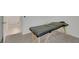 A massage table sits in a room with neutral carpet and white walls at 7011 Toll Mountain St, North Las Vegas, NV 89086