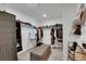 Walk-in closet featuring ample storage solutions, including shelves, hanging rods, and a comfortable seating area at 7011 Toll Mountain St, North Las Vegas, NV 89086