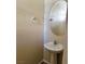 Powder room featuring a pedestal sink, chrome fixtures, round mirror, and neutral paint at 7563 Captain Lord Ct, Las Vegas, NV 89166