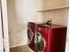 A laundry room features red washer and dryer units and a shelf at 7563 Captain Lord Ct, Las Vegas, NV 89166