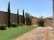 Landscaped backyard with gravel, artificial turf, and privacy wall at 7861 Hamilton Pool Dr, Las Vegas, NV 89113