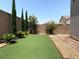 Well maintained backyard with artificial turf, landscaping, and privacy wall at 7861 Hamilton Pool Dr, Las Vegas, NV 89113