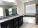 Bathroom showcasing dual sinks, a large mirror, a tub, and shower enclosure with dark stone accents at 7861 Hamilton Pool Dr, Las Vegas, NV 89113