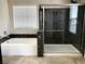 Bathroom with tub, glass-enclosed shower, and natural light from a window at 7861 Hamilton Pool Dr, Las Vegas, NV 89113