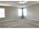 A large bedroom showcasing neutral decor, patterned carpeting, and abundant natural light from multiple windows at 7861 Hamilton Pool Dr, Las Vegas, NV 89113