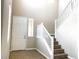 Bright entryway with wood-look flooring and a staircase with white railing leading to the upper level at 7861 Hamilton Pool Dr, Las Vegas, NV 89113