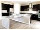 Bright kitchen with granite counters, stainless appliances, dark wood cabinets, and large island at 7861 Hamilton Pool Dr, Las Vegas, NV 89113