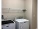 This laundry room features a washer, dryer, and shelving at 7861 Hamilton Pool Dr, Las Vegas, NV 89113