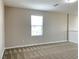 Cozy loft space featuring carpet, a window with blinds, and a view of the surrounding neighborhood at 7861 Hamilton Pool Dr, Las Vegas, NV 89113