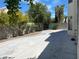 View of the backyard showing the concrete surface and block wall with trees, offering privacy and potential for landscaping at 8432 Apple Hill Ct, Las Vegas, NV 89128