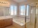 Bright bathroom features a soaking tub, separate shower, and natural light from two windows at 8432 Apple Hill Ct, Las Vegas, NV 89128