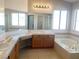 Spacious bathroom with double sinks and a large soaking tub under a bright window at 8432 Apple Hill Ct, Las Vegas, NV 89128