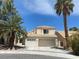 Charming two-story home features a three-car garage, tile roof, and mature palm trees in a desert landscape at 8432 Apple Hill Ct, Las Vegas, NV 89128