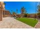 Serene backyard with pool, artificial turf, stone patio, and lush desert landscaping at 8809 Barium Rock Ave, Las Vegas, NV 89143