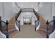 Grand foyer with a dual staircase and a view into the open living area at 8809 Barium Rock Ave, Las Vegas, NV 89143