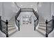 Grand foyer with a dual staircase and a view into the open living area at 8809 Barium Rock Ave, Las Vegas, NV 89143