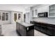 Spacious kitchen featuring white cabinets and a black island, under construction at 8809 Barium Rock Ave, Las Vegas, NV 89143