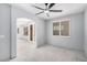 Spacious living room featuring an arched doorway, ceiling fan, and large windows for ample natural light at 8809 Barium Rock Ave, Las Vegas, NV 89143