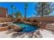Beautiful backyard pool with a rock waterfall feature, palm trees, and lush landscaping at 8809 Barium Rock Ave, Las Vegas, NV 89143