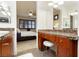 Bathroom vanity area features granite countertops, wood cabinets, and access to bedroom at 9050 W Tropicana Ave # 1102, Las Vegas, NV 89147