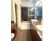 Bathroom featuring dual sinks, granite counters, and a glass-enclosed shower-tub at 9050 W Tropicana Ave # 1102, Las Vegas, NV 89147