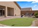 Landscaped backyard featuring a putting green, brick patio, and gravel groundcover at 942 Shadow Hawk Rdg, Mesquite, NV 89027