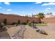 Landscaped backyard featuring a putting green, brick patio, and gravel groundcover at 942 Shadow Hawk Rdg, Mesquite, NV 89027