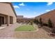 Landscaped backyard featuring a putting green, brick patio, and gravel groundcover at 942 Shadow Hawk Rdg, Mesquite, NV 89027
