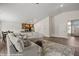 Spacious living room open to kitchen, featuring a large sectional sofa and wood-look tile flooring at 942 Shadow Hawk Rdg, Mesquite, NV 89027