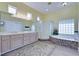 Bright bathroom boasts a dual sink vanity, a tiled tub, and glass enclosed shower at 10632 Clarion Ln, Las Vegas, NV 89134