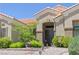 Inviting front entrance with double doors, decorative rock landscaping and manicured bushes at 10632 Clarion Ln, Las Vegas, NV 89134