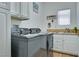 Functional laundry room is equipped with modern washer and dryer, cabinets, and sink for added convenience at 10632 Clarion Ln, Las Vegas, NV 89134