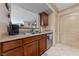 Galley kitchen with wood cabinets, granite countertops, and stainless steel dishwasher at 1150 N Buffalo Dr # 1007, Las Vegas, NV 89128