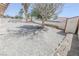 Spacious backyard featuring gravel landscaping, a mature tree, and privacy walls at 134 Saint Albans Dr, Henderson, NV 89015