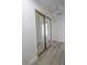 Hallway with mirrored closet doors and wood-look flooring; bright and modern at 134 Saint Albans Dr, Henderson, NV 89015