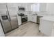 Updated kitchen with stainless steel appliances, white cabinets, gorgeous countertops, and wood-look flooring at 134 Saint Albans Dr, Henderson, NV 89015